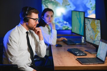 Center of dispatching maintenance. Portrait of cheerful woman and man working via headset...