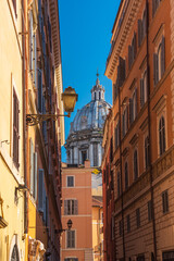 Fototapeta na wymiar a roman perpective with the cupola of Sant' Andrea della Valle at the end of the street