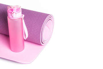 Yoga mat and water bottle isolated on white background.