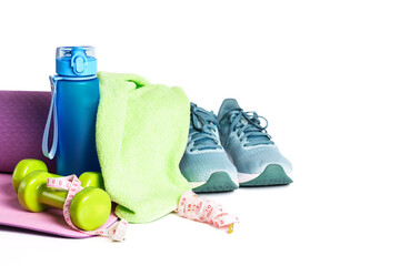 Yoga mat, sneakers, dumbbells and bottle of water isolated on white background.
