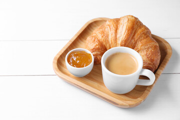 Breakfast time. Fresh croissant, jam and coffee on white wooden table. Space for text