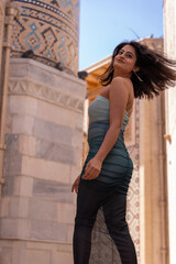 Obraz premium A woman in a dress is standing in front of a building