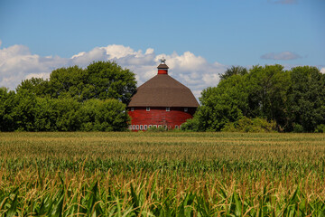 round barn behind a corn field