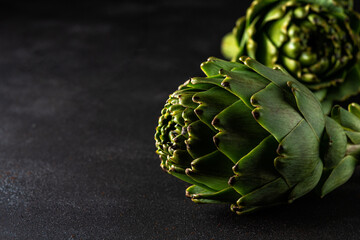 Ripe organic artichokes on a dark background. Vegetable concept.