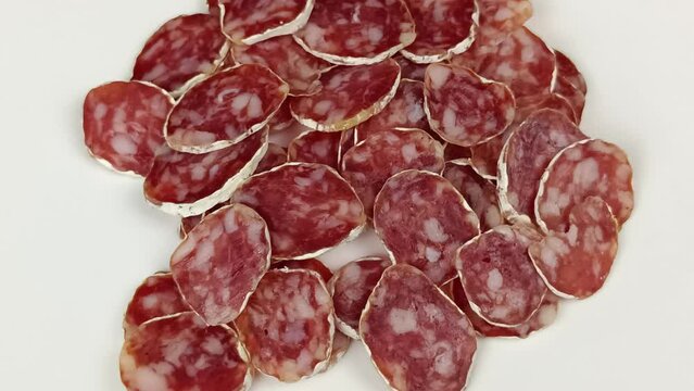 tranches de saucisson sec, en gros plan, isol&eacute; sur un fond blanc