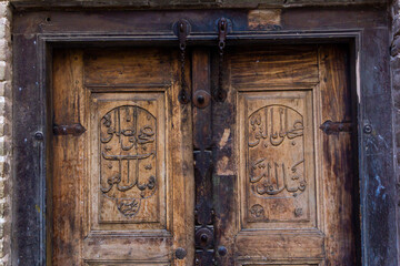 Wooden door with Arabic calligraphy on it representing traditional architecture with perfect...
