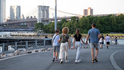 Family Walk Along the Brooklyn Bridge Park at Dusk