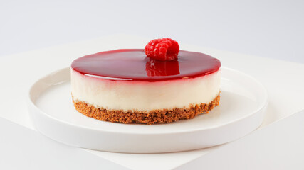 Cheesecake with raspberries on a white plate on a white background