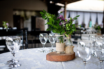 Table arrangement with green flower and glasses on the wooden table
