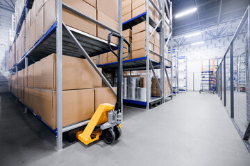 Large modern warehouse for med material and rack with card boxes with hand yellow forklift