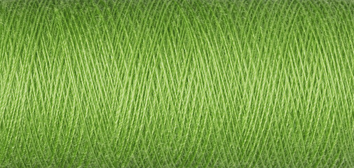 macro texture of a skein of green sewing thread
