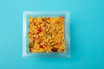 Delicious vegetarian couscous with tomatoes, carrots, zucchini, yellow bell pepper in plastic box