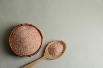 Himalayan salt in bowl and spoon on grey background, flat lay. Space for text