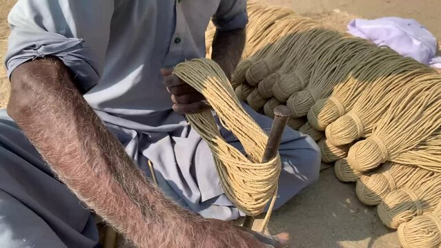 Hand Made Ropes In Pakistan. making ropes with hand for sleeping bed known as charpai in Pakistan. Different achievements of knot and assembly of boat ropes. Man is becoming a ropes. 4K Footage.