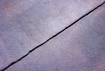 Diagonal crack in street asphalt texture background