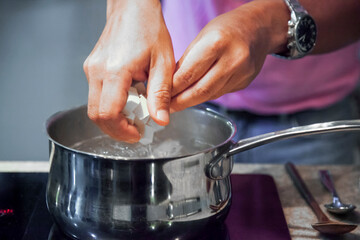 A Man's Hands Crafting Miso Soup with Tofu. He is wearing a pink shirt