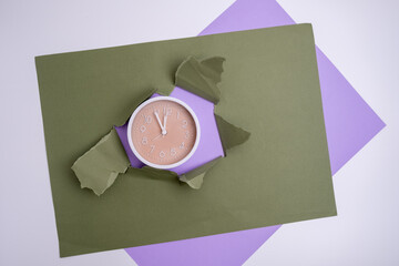 White alarm clock on a colored background. Fashionable minimalist style. Time, business and technology concept. Flat composition. View from above