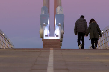 Pareja caminando de espaldas porPuente atirantado asimétrico triangular Puerta de las rozas. Comunidad de Madrid. España - obrazy, fototapety, plakaty
