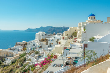 View of Oia town with traditional and famous houses and churches with blue domes over the Caldera on Santorini island. Greece.