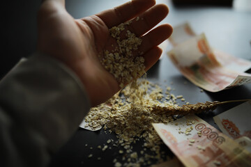 The concept of the cost of grain. 5000 ruble banknotes around a handful of ground grain. World...