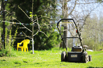 Lawnmower on a green meadow in spring