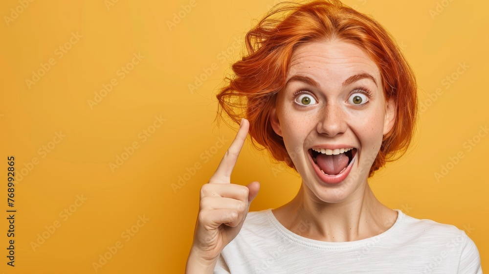 Poster enthusiastic girl pointing on gentle colored background with ample space for text placement