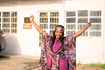 A photo of an African lady excited about life and Embracing the Sunshine. in her Native Ankara
