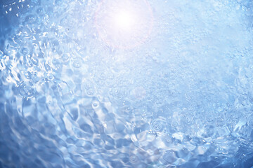 Bubbles and seething water in the light of sunlight.Blue water texture.