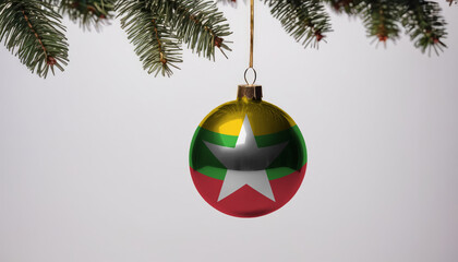 New Year's ball with the flag of Myanmar on a Christmas tree branch isolated on white background. Christmas and New Year concept.
