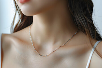 minimalist silver chain necklace that is easy to match and looks cool around a neck of woman - obrazy, fototapety, plakaty