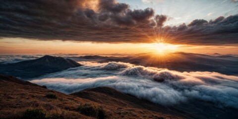 Naklejka na ściany i meble The sun sets behind the clouds atop a mountain, revealing a valley and distant mountains