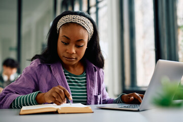 Black female student learning at university library.
