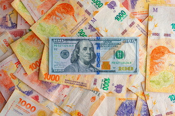 Billete de 100 dolares sobre billetes de 1000 pesos