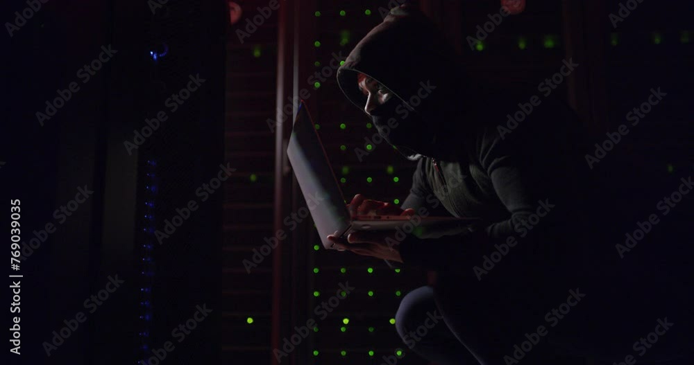 Leinwandbilder Hacker, server room and laptop for coding, data center crime and ransomware or cybersecurity network. Person, thief or programmer in mask and hoodie on computer, firewall or hacking in dark or night