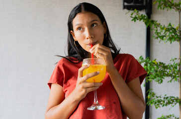 retrato de joven latina tomando un coctel 