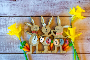 Wooden Easter bunnies with decoration and the text Easter written on eggs.