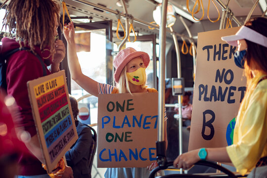 Activists with protest signs about climate change on a bus