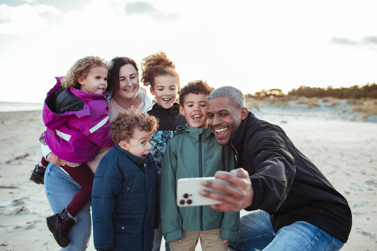 Young mixed family taking a selfie on the beach