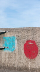 Pintura roja y azul en muro de hormigón de puerto
