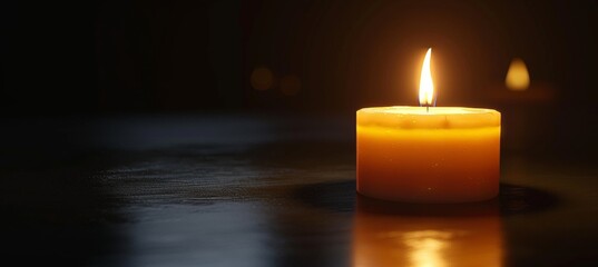 Gothic style burning candle on black background with ample space for text placement