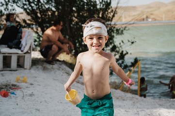 happy child kindergarten boy resting on the beach in summer