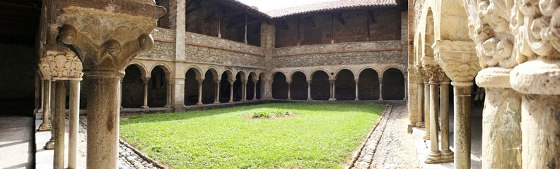 Panoramic view of the Romanesque cloister of the Saint-Lizier cathedral. XII century. Semicircular arches and pillars with beautiful capitals. Ariege. Occitanie. France