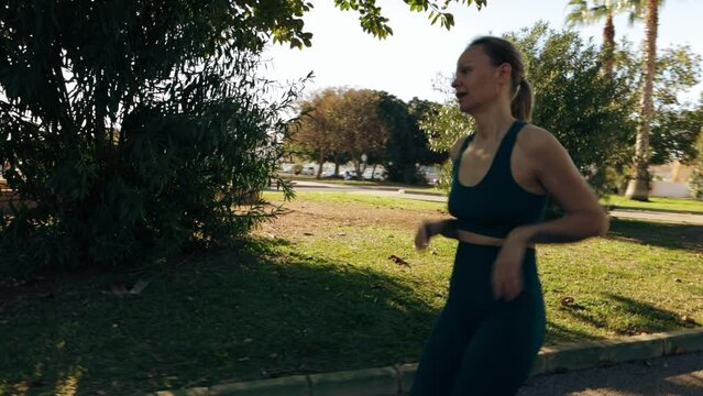 girl runs in  palm park, stopping to rest before continuing her run again