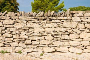 Typical old French dry wall built with stacked stones not fixed with mortar but simply overlapped...