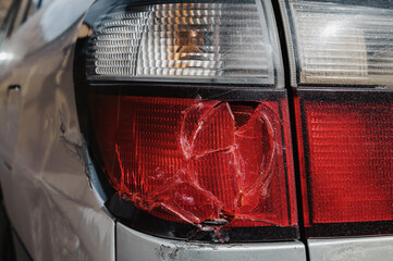 old car after an accident with a damaged broken taillight close-up