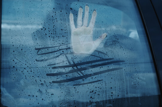 Concept of illegal kidnapping, trafficking and slavery. Woman girl female hand on car window for help and rescue from a kidnapper
