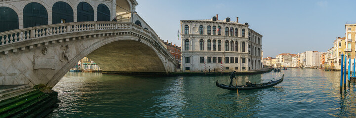 Panorama of the famous Rialto bridge with a gondola boat on the Canal Grande on a sunny winter day, Venice, Veneto, Italy