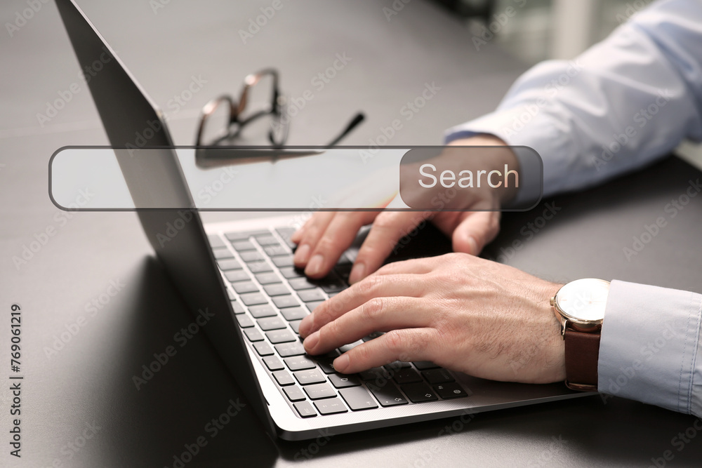 Poster search bar of website over laptop. man using computer at grey table, closeup