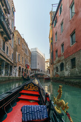 Gondola ride through the canals with view from inside the boat at the bridge Ponte Santi Apostoli,...