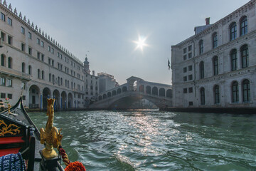 Gondola ride through the Canal Grande with view from inside the boat at the Rialto bridge, Venice,...